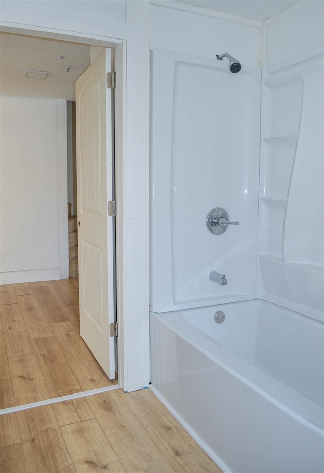 bathroom featuring tub / shower combination and wood finished floors