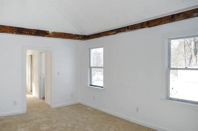 unfurnished room with light carpet, visible vents, baseboards, and lofted ceiling