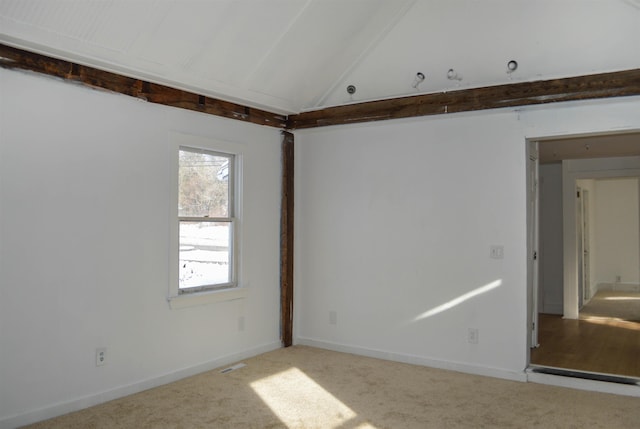 spare room with vaulted ceiling with beams, carpet floors, and baseboards