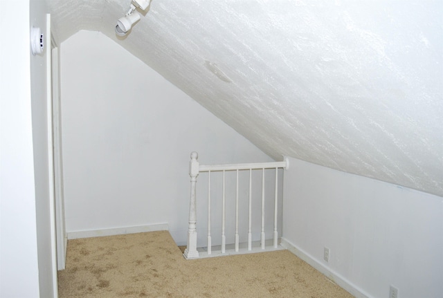 bonus room featuring carpet floors, vaulted ceiling, a textured ceiling, and baseboards