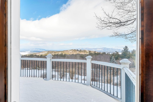 snow covered deck with a mountain view