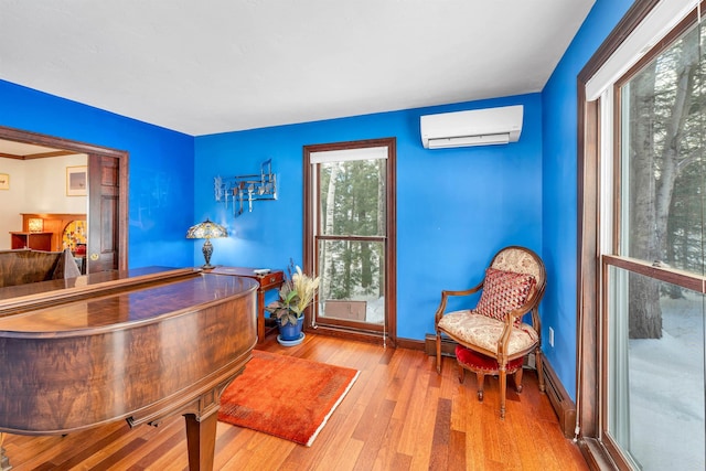 home office featuring an AC wall unit and light hardwood / wood-style flooring