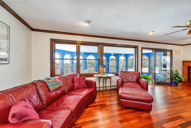 living room with hardwood / wood-style floors, a healthy amount of sunlight, and baseboard heating