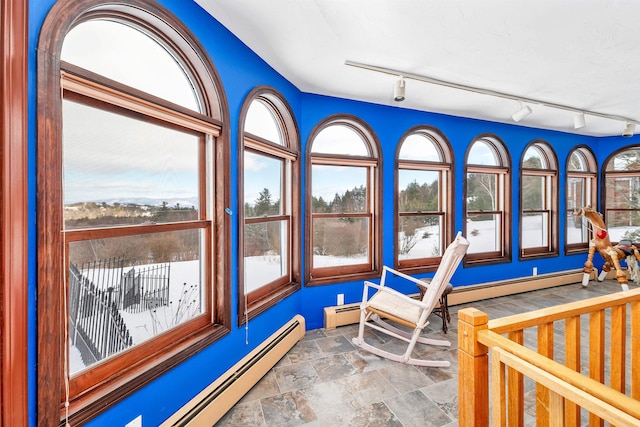 interior space featuring rail lighting and baseboard heating