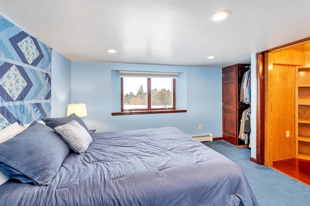 bedroom with a closet, carpet floors, and a baseboard radiator