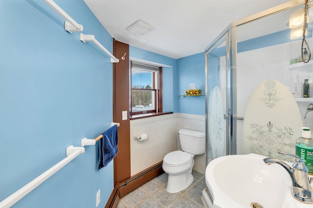 bathroom with tile walls, sink, an enclosed shower, and toilet