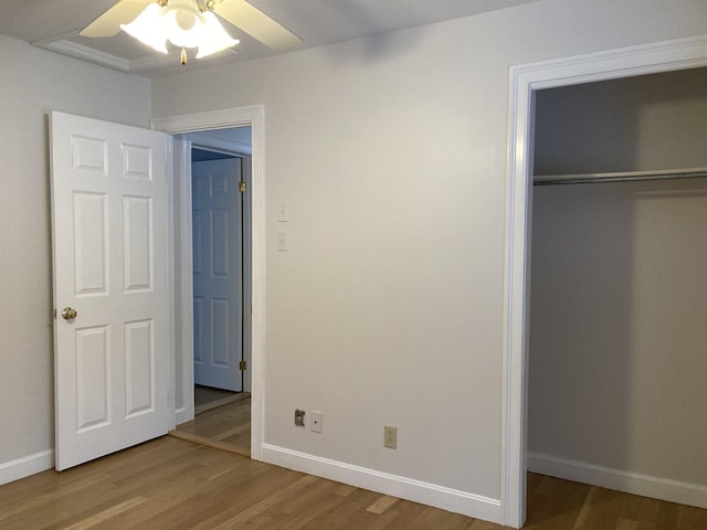 unfurnished bedroom featuring hardwood / wood-style flooring, ceiling fan, and a closet