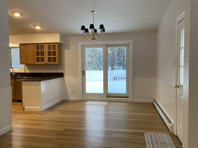 doorway featuring a baseboard radiator, a notable chandelier, and light hardwood / wood-style floors