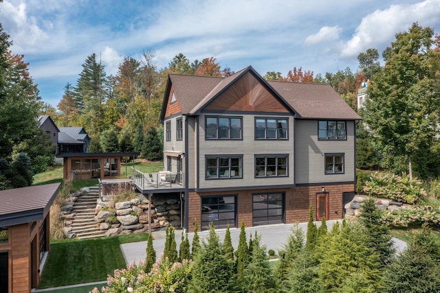 back of property with a garage and a deck