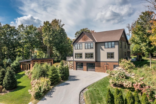 english style home featuring a garage and a front lawn