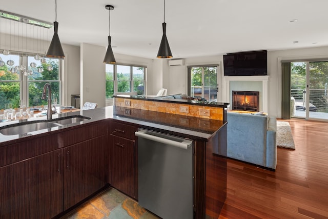 kitchen with sink, dark brown cabinets, dark hardwood / wood-style floors, a wealth of natural light, and an AC wall unit