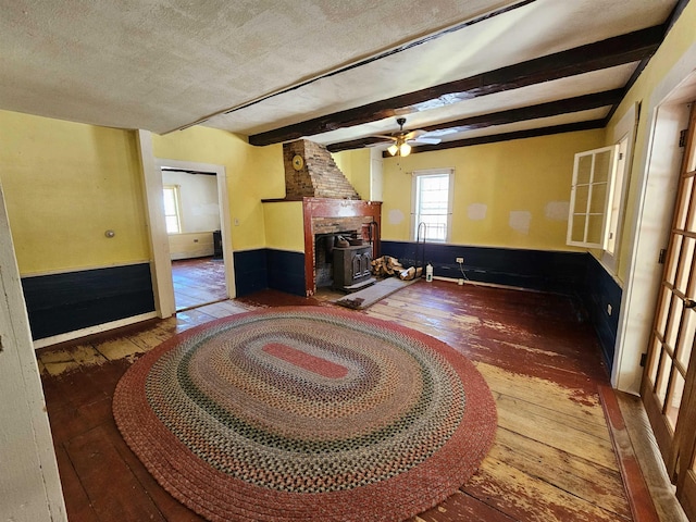 living room with a textured ceiling, wood-type flooring, and beamed ceiling