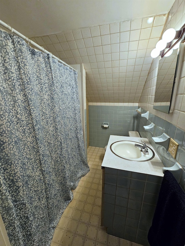 bathroom featuring vanity and tile walls