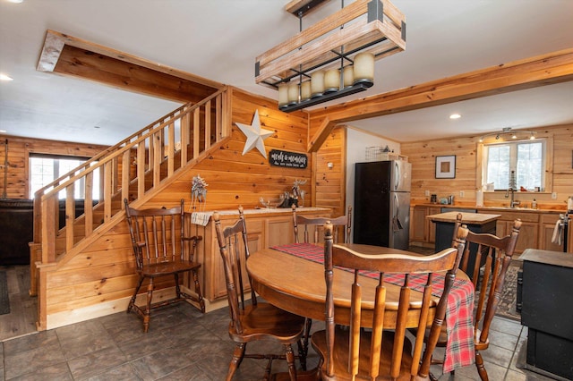 dining room featuring wooden walls, sink, and a wealth of natural light