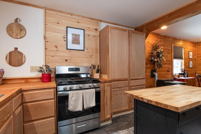 kitchen featuring wooden counters, beam ceiling, light brown cabinets, stainless steel range with gas cooktop, and wood walls