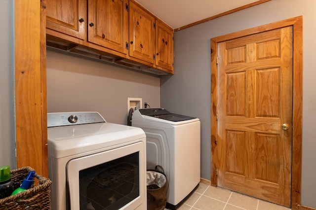 washroom with cabinets, washing machine and dryer, and light tile patterned floors