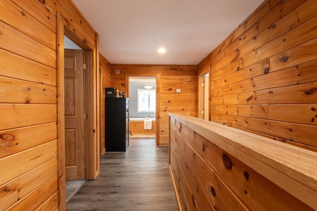 hall featuring dark wood-type flooring and wood walls