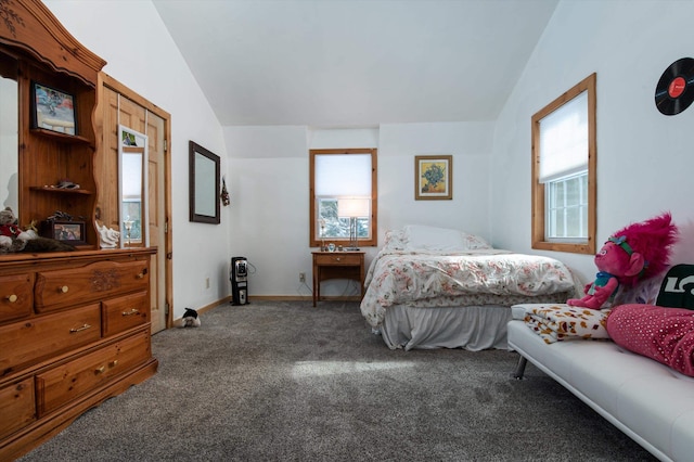 carpeted bedroom featuring multiple windows and lofted ceiling