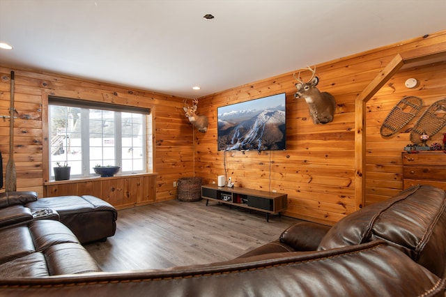 living room with hardwood / wood-style flooring and wooden walls