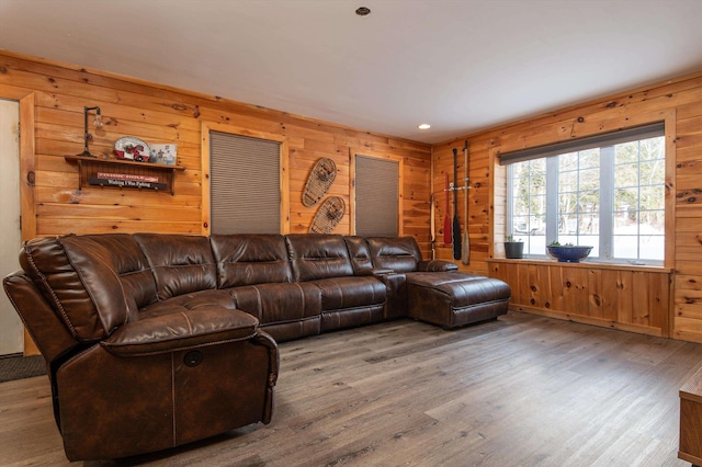 living room with hardwood / wood-style flooring and wood walls