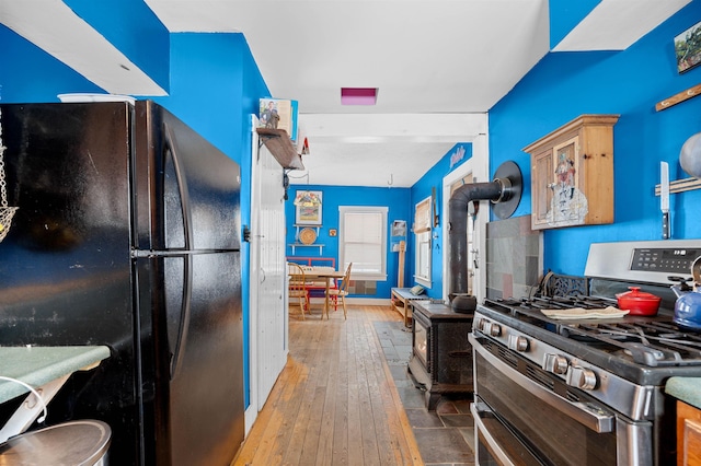 kitchen featuring range with two ovens, black refrigerator, and dark hardwood / wood-style flooring