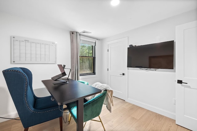 home office with light hardwood / wood-style floors