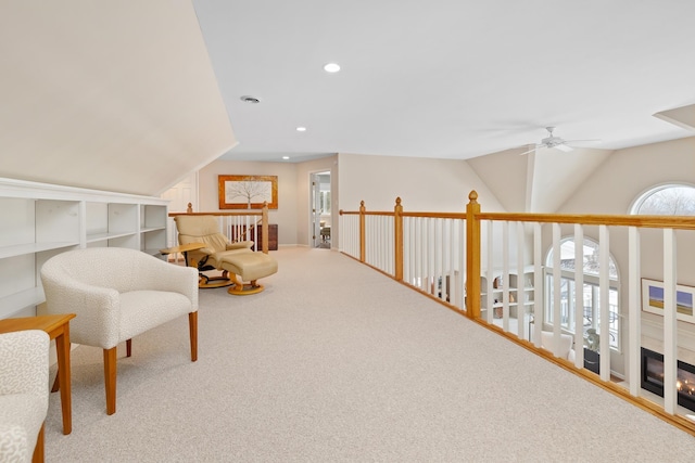 living area with ceiling fan, lofted ceiling, and carpet