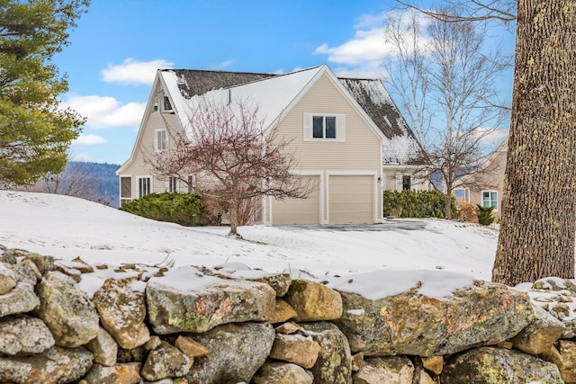 snow covered property featuring a garage