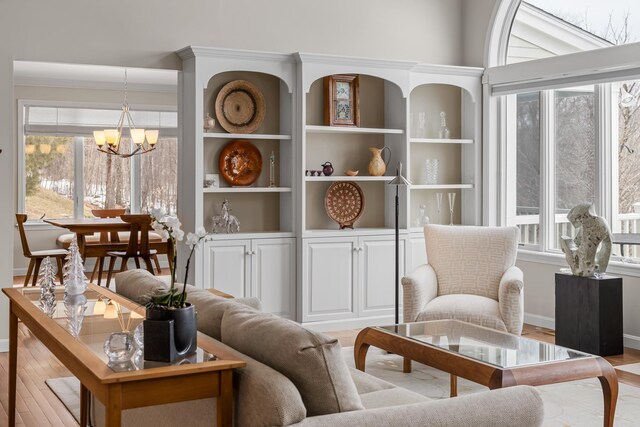 sitting room featuring ornamental molding, light hardwood / wood-style floors, and a notable chandelier