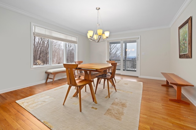 dining room featuring a healthy amount of sunlight, ornamental molding, and light wood-type flooring