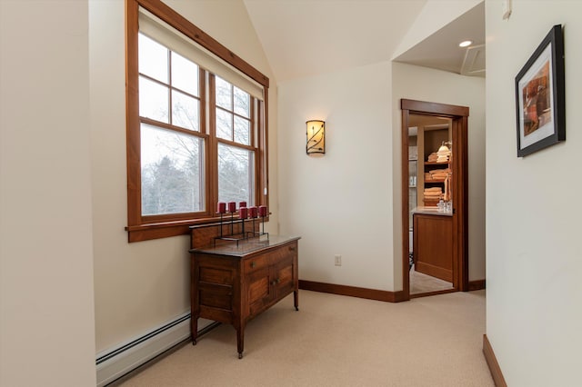 hall with lofted ceiling, a baseboard heating unit, and light carpet