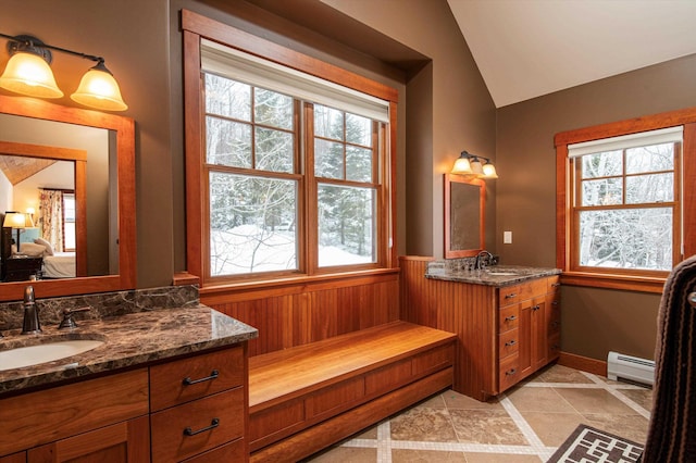 bathroom featuring vanity, a baseboard heating unit, vaulted ceiling, and plenty of natural light