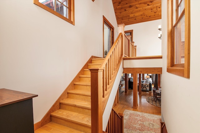 staircase with hardwood / wood-style floors, wood ceiling, and high vaulted ceiling