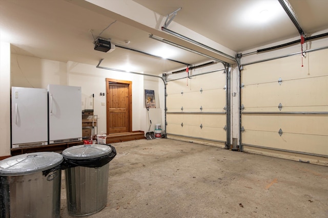 garage with a garage door opener and white fridge