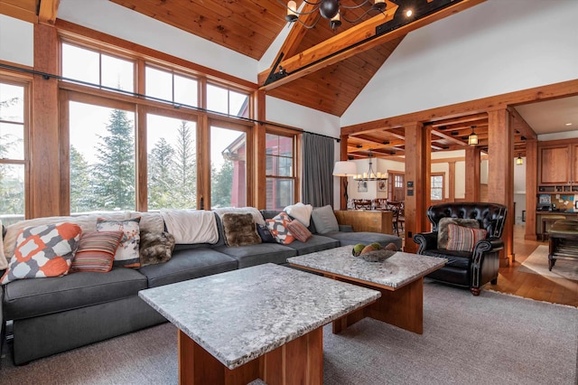 living room featuring wood ceiling, high vaulted ceiling, light hardwood / wood-style floors, and a chandelier