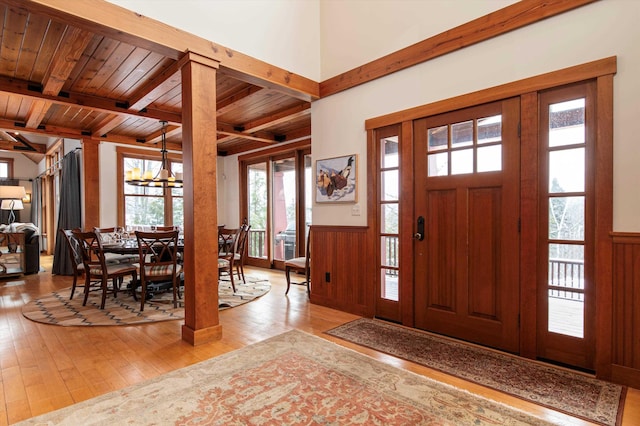 entryway featuring a notable chandelier, wood ceiling, beam ceiling, and light hardwood / wood-style floors