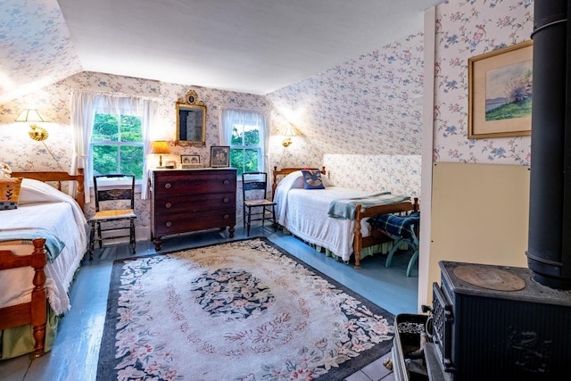 bedroom with vaulted ceiling, a wood stove, and dark hardwood / wood-style floors