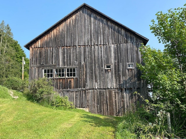 view of side of home with a yard and an outbuilding