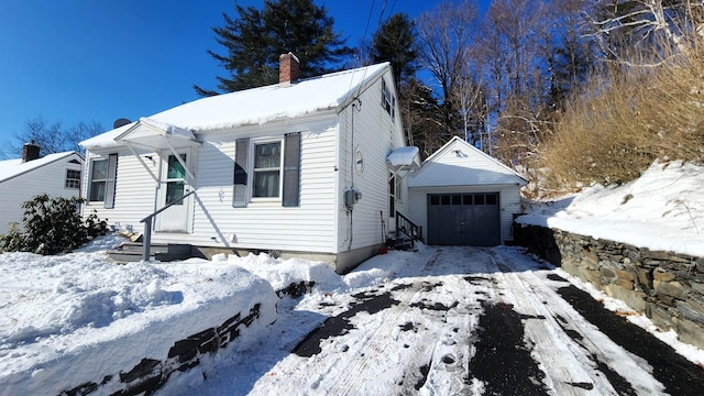 view of front of home with a garage and an outdoor structure