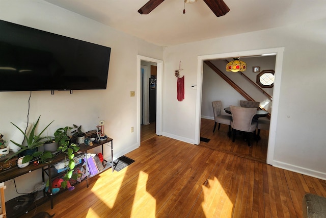 living room featuring wood-type flooring and ceiling fan