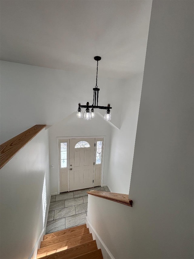 foyer entrance with vaulted ceiling and light hardwood / wood-style floors