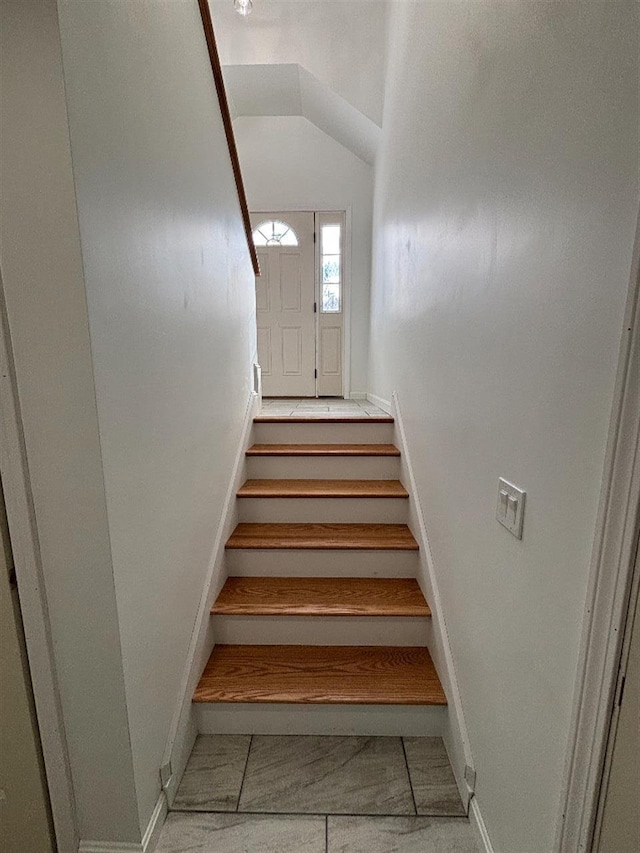 staircase featuring vaulted ceiling