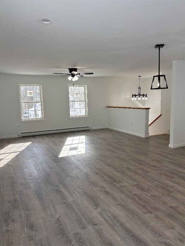 unfurnished room with a baseboard heating unit, dark wood-type flooring, and ceiling fan