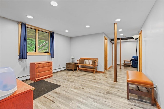 sitting room with a baseboard heating unit and light wood-type flooring