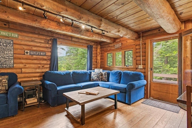 sunroom featuring wood ceiling, a healthy amount of sunlight, and beamed ceiling