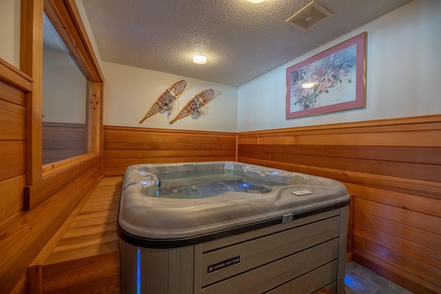 bathroom featuring vanity, a textured ceiling, and wooden walls