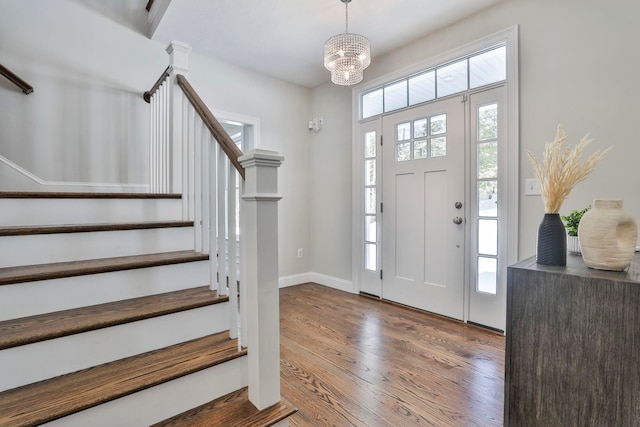 entryway with hardwood / wood-style floors and an inviting chandelier