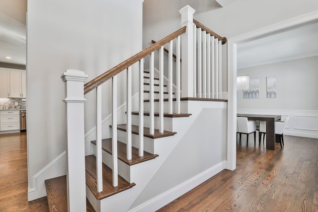 staircase with crown molding and hardwood / wood-style floors