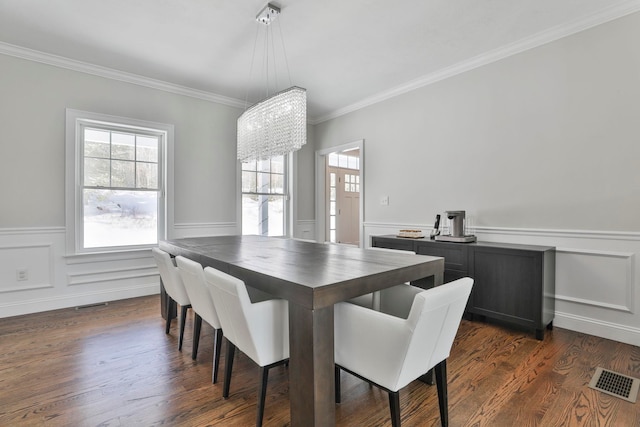 dining space with ornamental molding, a notable chandelier, and dark hardwood / wood-style flooring