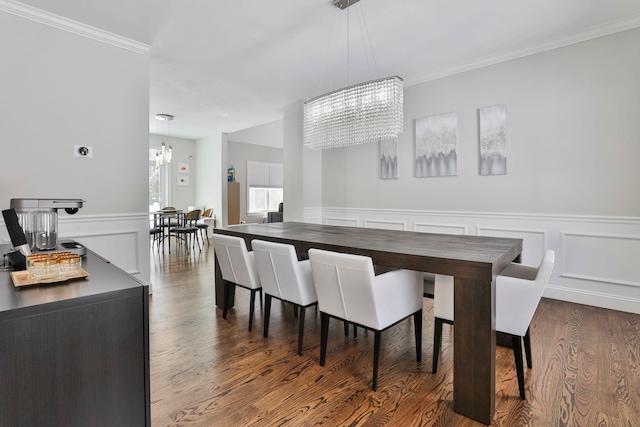 dining room featuring an inviting chandelier, crown molding, and dark wood-type flooring